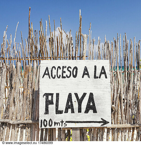 Zugangsschild zum Strand auf Spanisch  an einem Zaun am Strand