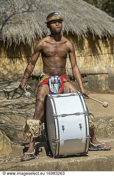 Zulu-Mann in traditioneller Kleidung spielt die Trommel
