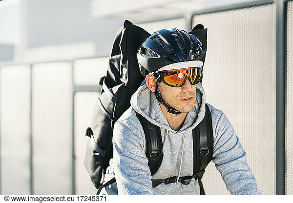 Zusteller mit Sonnenbrille und Fahrradhelm