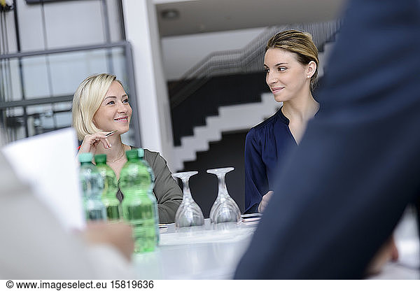 Zuversichtliche Geschäftsfrauen in einer Sitzung  lächelnd