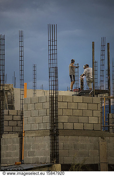 Zwei Bauarbeiter arbeiten auf dem Dach oder auf dem Dach und schweißen Metallgeländer.