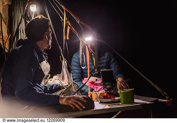 Zwei Bergsteiger sitzen nachts auf der Portalege  Liming  Provinz Yunnan  China