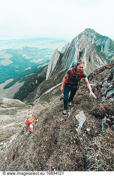 Zwei Bergsteigerinnen besteigen einen steilen Berg in der Schweiz