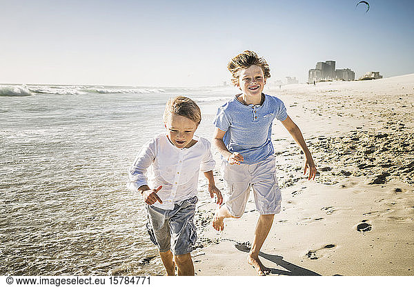 Zwei Brüder laufen am Strand