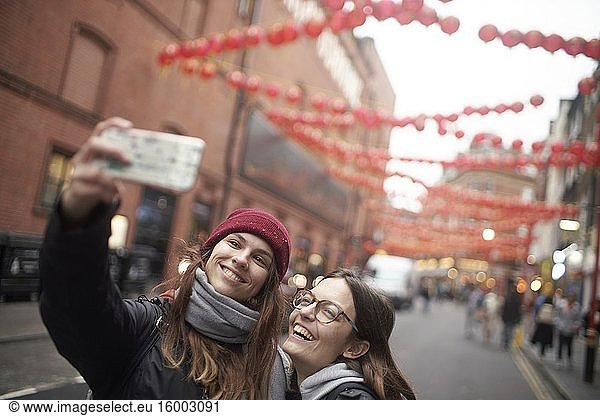Zwei Frauen machen ein Selfie in China Town in London  Großbritannien.