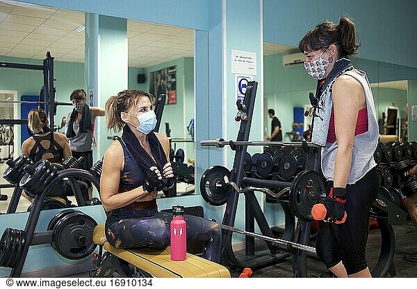 Zwei Freunde machen eine Pause beim gemeinsamen Training im Fitnessstudio