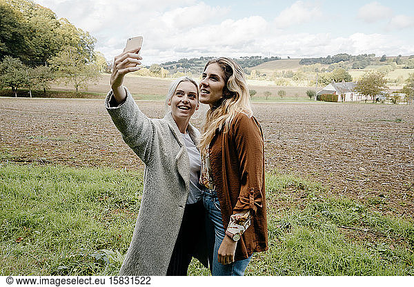 Zwei Freundinnen beim Selfie in einer französischen Landschaft auf dem Land