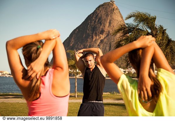 Zwei Freundinnen beim Training im Park mit Personal Trainer  Rio De Janeiro  Brasilien