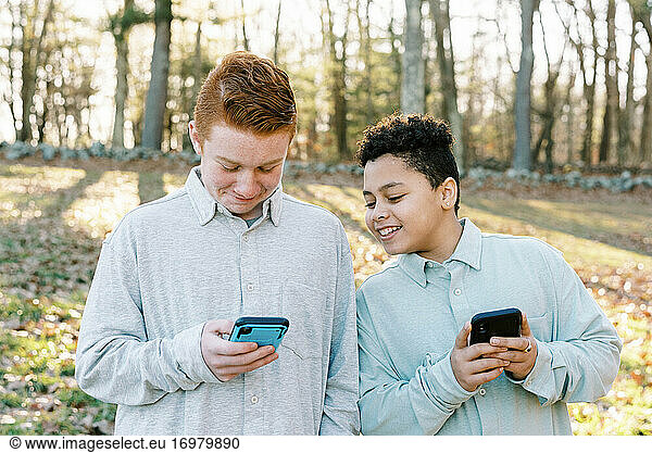 Zwei gemischtrassige Brüder spielen ein Spiel auf einem Smartphone
