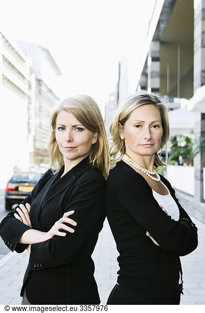 Zwei Geschäftsfrauen  die Rücken an Rücken stehen.