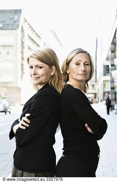 Zwei Geschäftsfrauen  die Rücken an Rücken stehen.