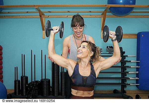 Zwei junge Frauen trainieren in einem Fitnessstudio  machen Krafttraining