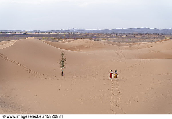 Zwei junge Frauen wandern in der Wüste Sahara  Merzouga  Marokko