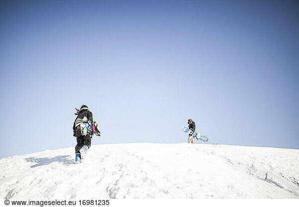 Zwei junge Leute  die zusammen Snowboard fahren