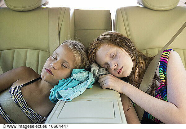 Zwei junge Mädchen schlafen nach dem Spielen im Auto ein