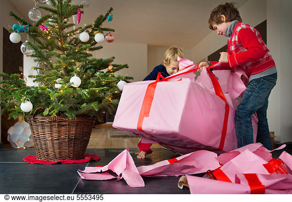 Zwei Jungen beim Auspacken von Weihnachtsgeschenken