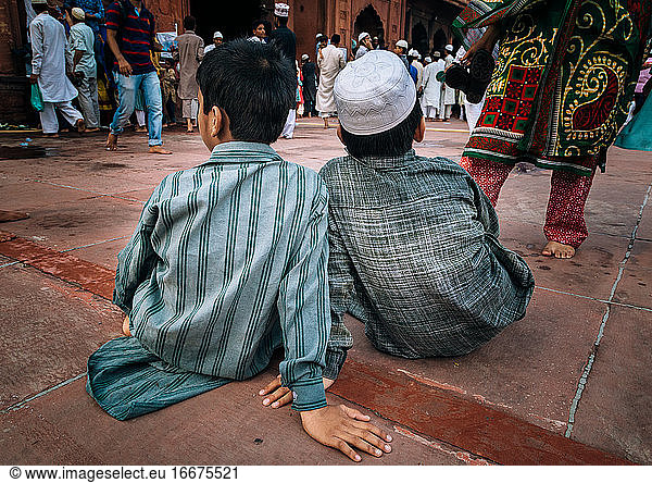 Zwei Kinder beobachten die Menschenmenge in der Jama Masjid  Delhi  Indien