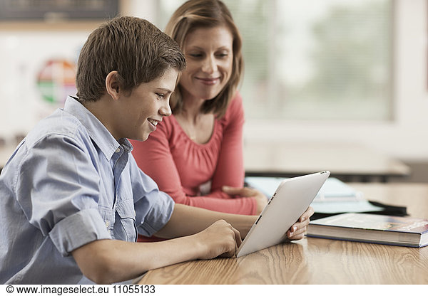 Zwei Kinder  ein Junge und ein Mädchen  die sich ein digitales Tablett teilen.