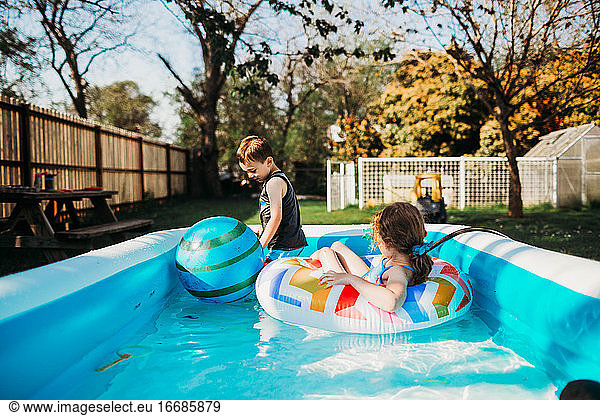 Zwei Kinder im Vorschulalter schwimmen im Pool im Hinterhof