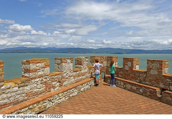 Zwei Kinder stehen an Burgzinnen  Fortezza  Rocca del Leone  Castiglione del Lago  am Trasimener See  Lago Trasimeno  Umbrien  Italien  Europa