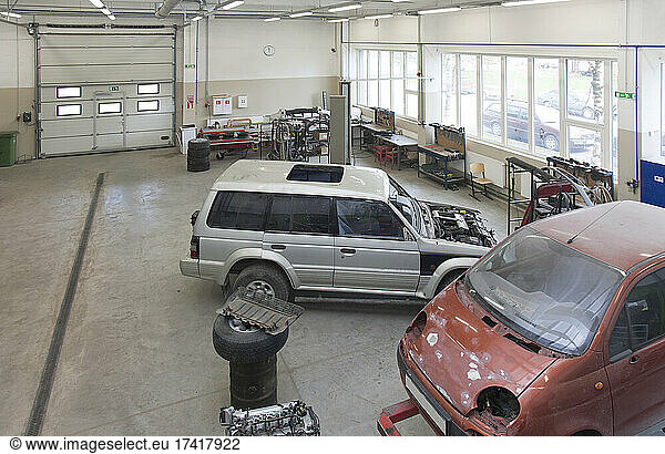 Zwei Kleintransporter in einer großen Reparaturwerkstatt oder Garage.