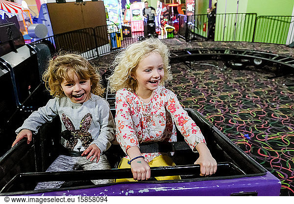 zwei lächelnde und lachende Mädchen auf der Achterbahn  die Spaß haben