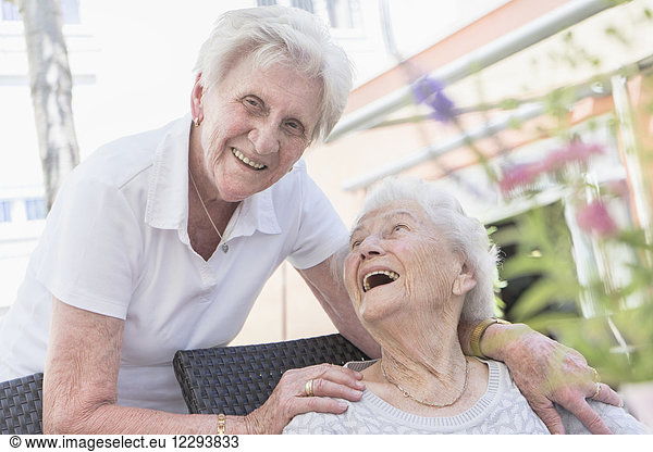 Zwei lachende Seniorinnen im Pflegeheim
