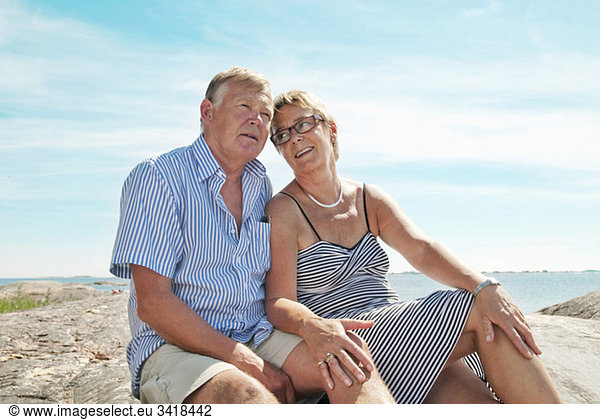 Zwei ältere Menschen am Strand sitzend