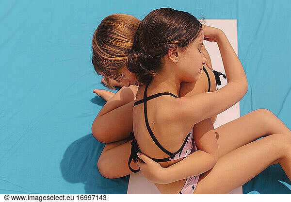 Zwei Mädchen in Badekleidung  die sich umarmen
