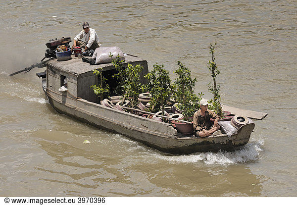 Zwei Männer fahren auf einem Holzboot am Mekong  Pflanzenhändler  Can Tho  Mekongdelta  Vietnam