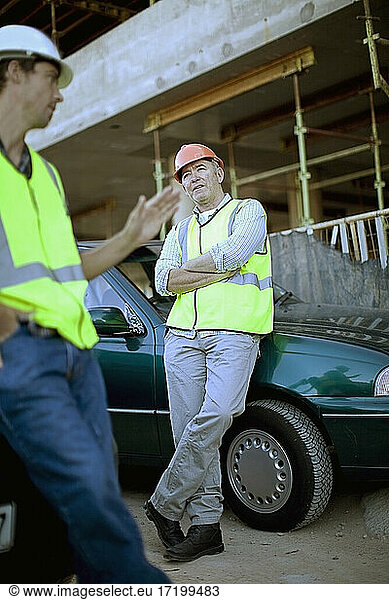 Zwei männliche Bauarbeiter unterhalten sich im Freien