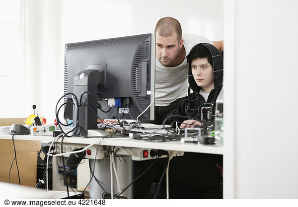 Zwei Menschen helfen sich gegenseitig am Computer.