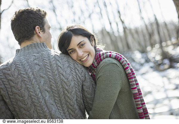 Zwei Personen  ein Paar an einem Wintertag im Freien. Einander umarmend.