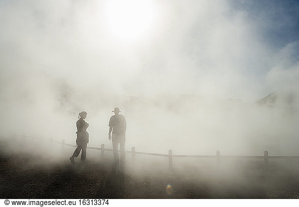 Zwei Personen im aufsteigenden Nebel an einem Thermalbad