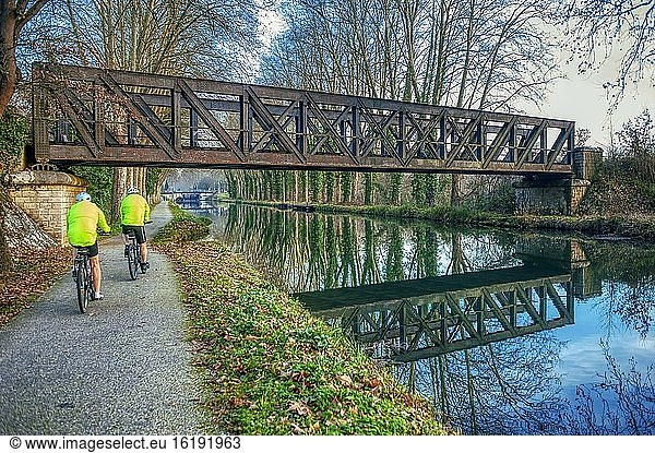 Zwei Radfahrer unter einer alten Eisenbahnbrücke  Canal de Garonne westlich von Marmande  Departement Lot-et-Garonne  Aquitanien  Frankreich.