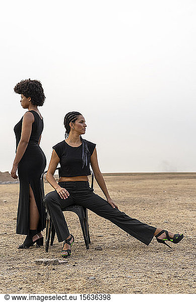 Zwei schwarz gekleidete Frauen in trostloser Landschaft