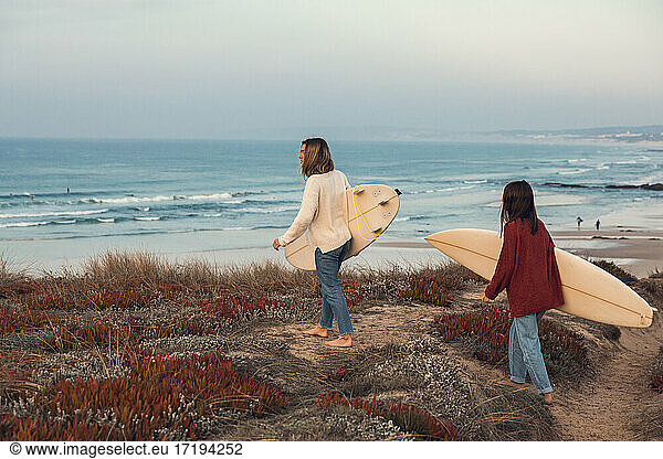 Zwei Surferinnen gehen surfen