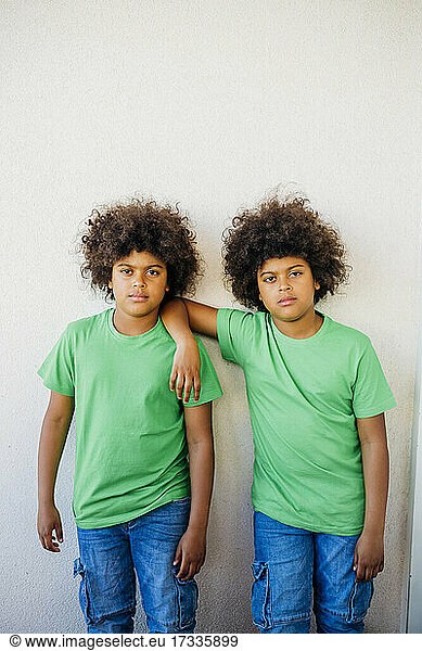 Zwillingsbrüder stehen vor einer weißen Wand