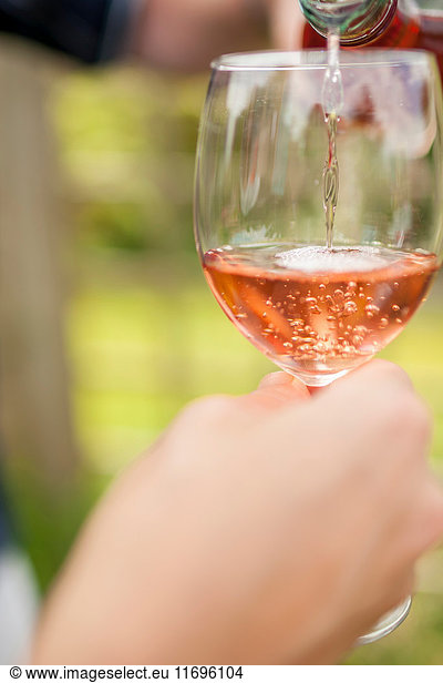 Woman pouring glass of wine outdoors