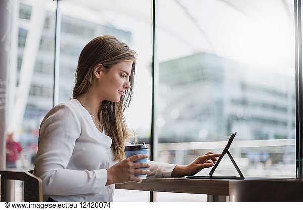 Young businesswoman in a cafe using tablet