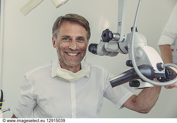 Dentist using microscope, portrait