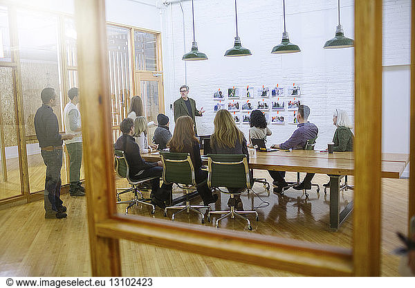 Business people in meeting at board room seen through glass